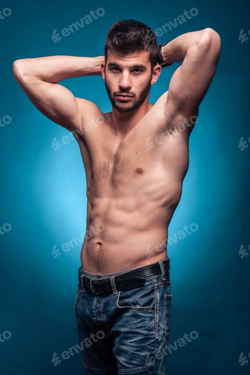 Preview: One Young Adult Man, Shirtless Body, Arms Raised Behind Head, Jeans, Blue Background