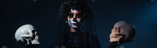 Preview: woman in creepy halloween costume and makeup holding skulls on black and blue background, banner