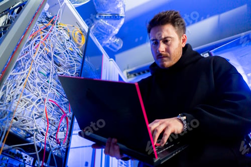 Preview: focused hacker in data center hacking software system vulnerable cyber security server room