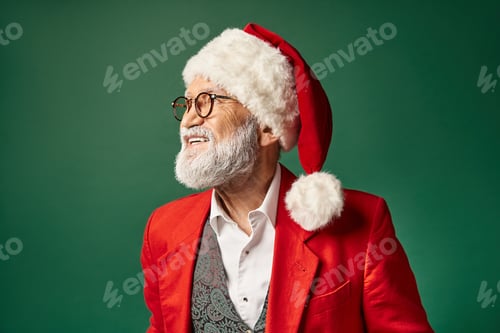 Preview: cheerful elegant Santa in christmassy hat and glasses smiling and posing in profile, winter concept