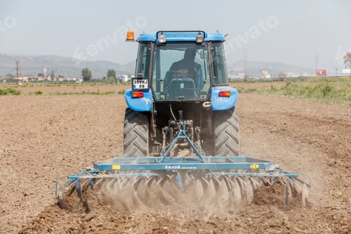 Preview: Tractor ploughing on the field in sunlight
