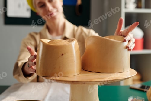 Preview: Selective focus on hands of creative woman touching wooden workpieces