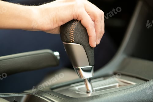 Preview: Close up of woman driver holding her hand on automatic gear shift stick driving as car