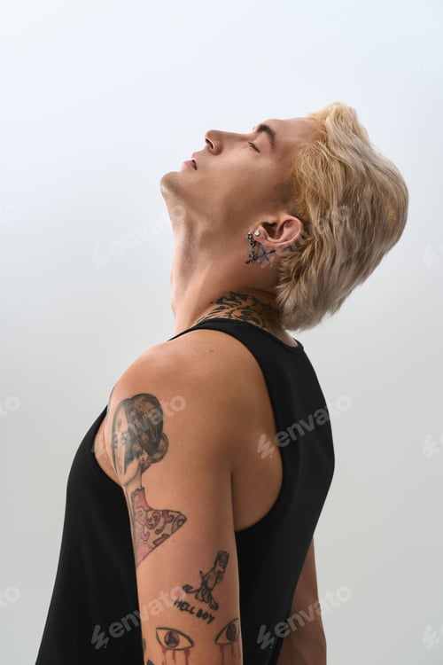 Preview: Handsome young man displays fashionable style with a confident pose against a minimalist backdrop