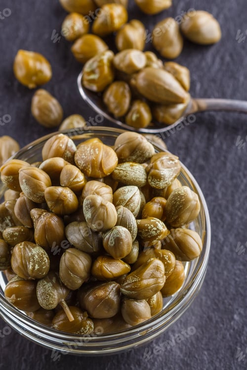 Preview: pickled capers on a dark stone background