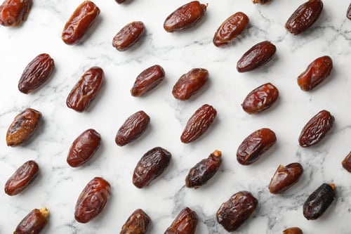 Preview: Flat lay composition with dates on marble background. Dried fruit as healthy snack