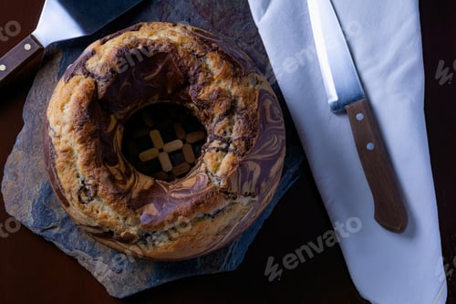 Preview: High angle shot of a delicious homemade marble pound cake on a slate board with kitchen utensils