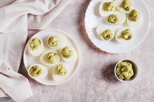 Preview: Eggs stuffed with avocado and yolk mixture on a plate on a table top view