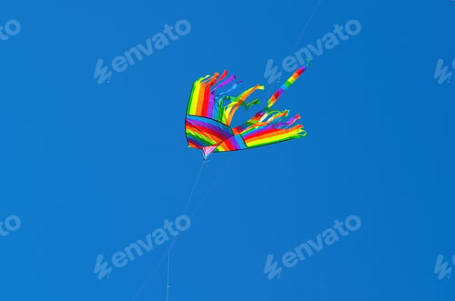 Preview: colorful kites in blue sky with small white clouds