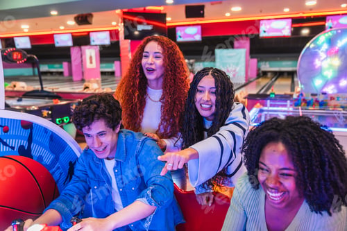 Preview: Friends playing arcade basketball game in bowling alley