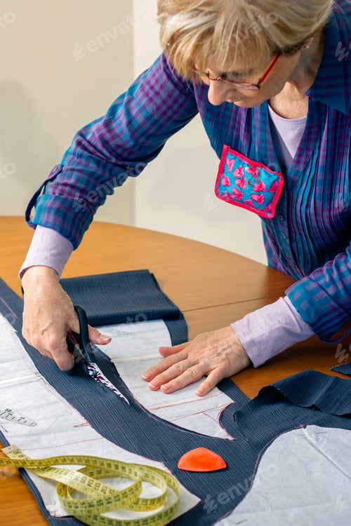 Preview: Dressmaker cutting a cloth