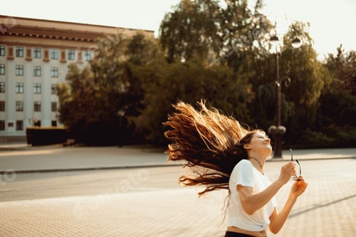 Preview: Happy young brunette woman enjoying summer in a city. Real woman urban portrait.