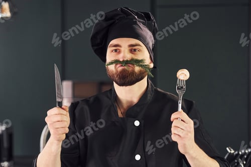 Preview: Portrait of professional young chef cook in uniform that posing for camera on the kitchen