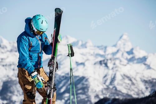 Preview: Skier contemplating the mountain view before the descent.