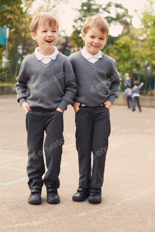 Preview: Two smiling boys in school uniforms enjoying a playful moment