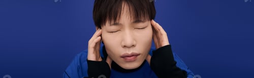 Preview: Expressive young asian man experiencing contemplation against a vibrant blue backdrop