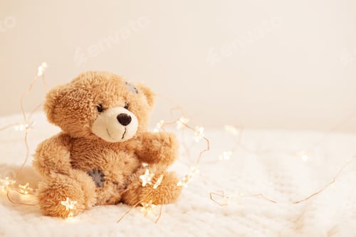 Preview: Toy teddy bear on soft plaid background with beautiful Christmas lights