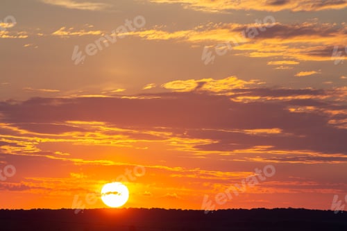 Preview: Sunset sky covered with orange puffy clouds in the evening