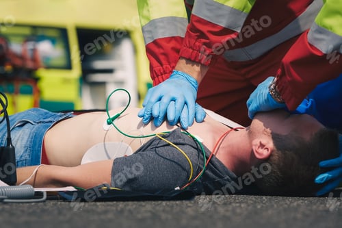 Preview: Hands of paramedic and doctor of emergency service during resuscitation on road