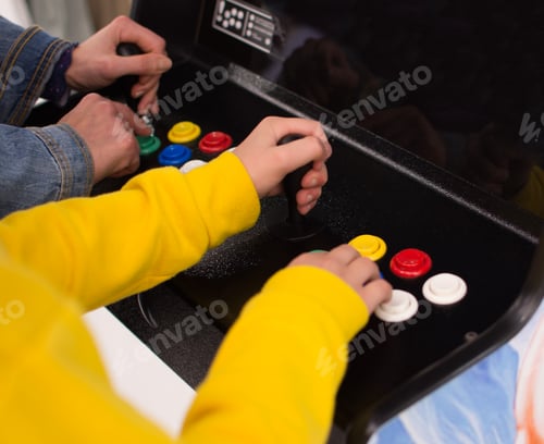 Preview: Detail on hands playing with joystick on old vintage arcade game in a dark room for playing video ga