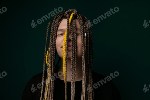 Preview: Woman With Long Dreadlocks in Front of Green Background