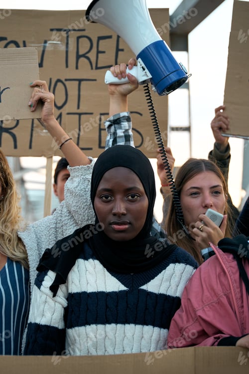 Preview: Serious Muslim woman in the middle of a demonstration by a group of activists people