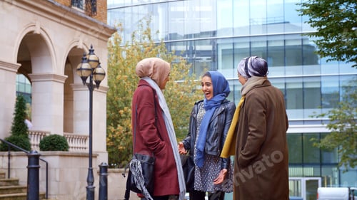Preview: Group Of Young British Muslim Businesswomen Meeting And Talking Outside Office