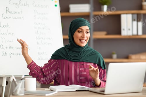 Preview: Muslim English teacher pointing on board, explaining lesson to students