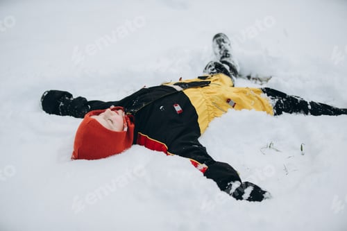 Preview: Child playing in snow making angel