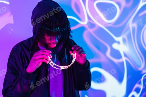 Preview: Afro man putting on smart goggles in studio