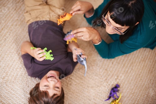 Preview: Watch out for the Ticklesaurus. Cropped shot of a mother and her son playing with toy dinosaurs.
