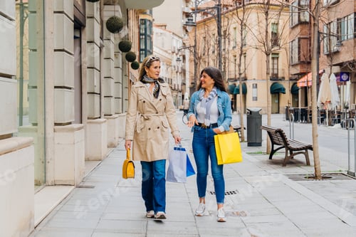 Preview: Two mature women walking and talking after shopping spree