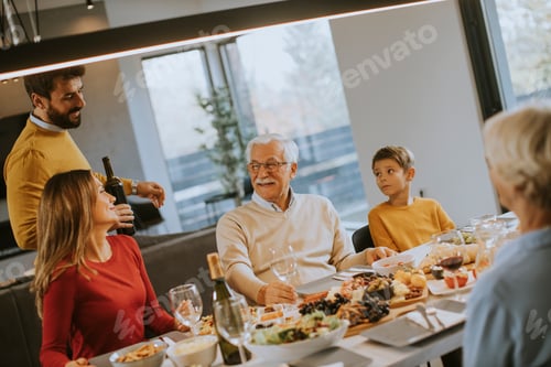 Preview: Young man poring red wine to his father for testing during at home