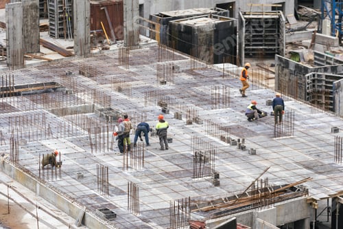 Preview: Construction workers collaborating in the installation of cement formwork frames