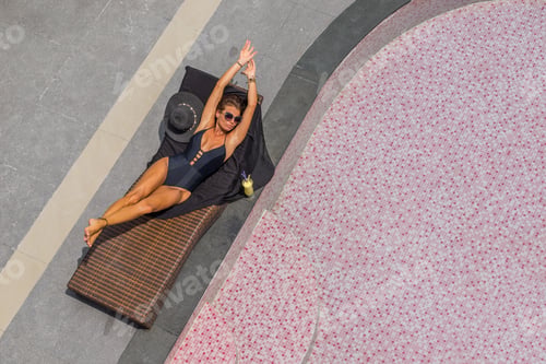 Preview: Beautiful woman enjoying summer and tanning at the swimming pool