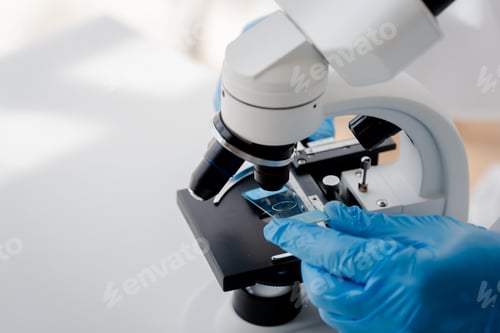 Preview: Doctor or research scientist looking under microscope analyzing test sample in laboratory biotechnol