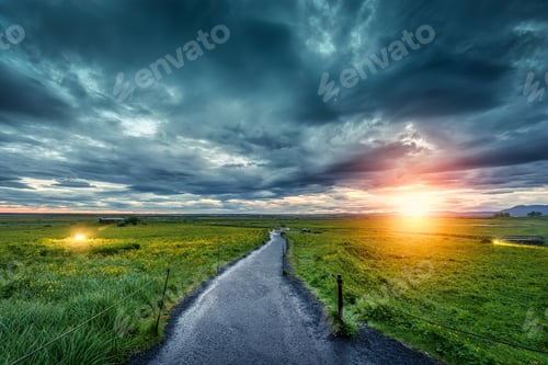 Preview: View of pathway on agricultural field and moody sky in summer