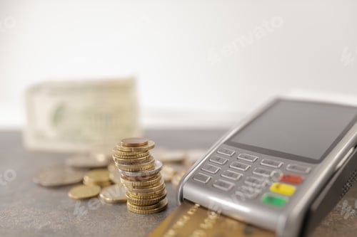 Preview: Closeup shot of coins and a pos terminal on the table