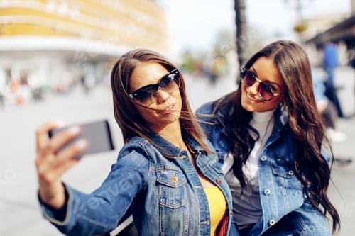 Preview: Two beautiful young woman taking selfie