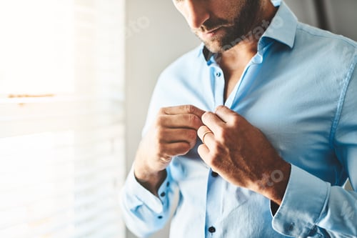 Preview: Man Buttons his Shirt in Bright Daylight