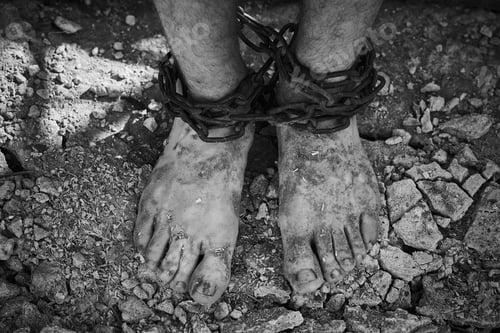 Preview: Close-up shot of barefoot legs tied up with old chain