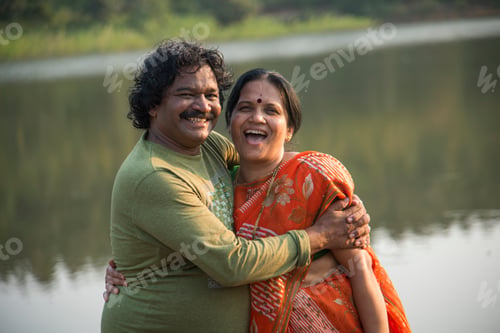 Preview: Indian couple having fun, holding each other standing near lake, Indian lifestyle portrait.