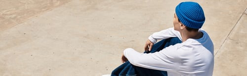 Preview: Relaxing moment in the park with a young man wearing a blue beanie