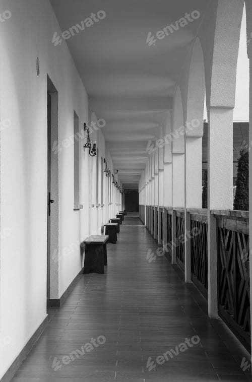 Preview: long narrow corridor leading to multiple door sections with white walls