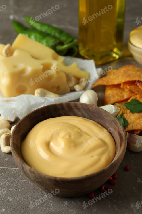 Preview: Bowls with cheese sauce and ingredients on gray textured table