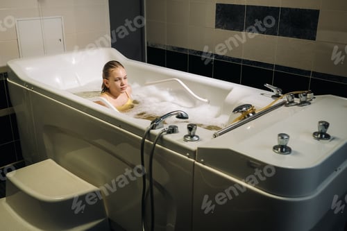 Preview: a little girl takes the procedure in a mineral bath. The patient receives water treatments with a