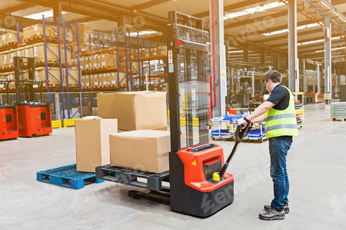 Preview: Caucasian employee working on modern warehouse. Industrial man using forklift with box