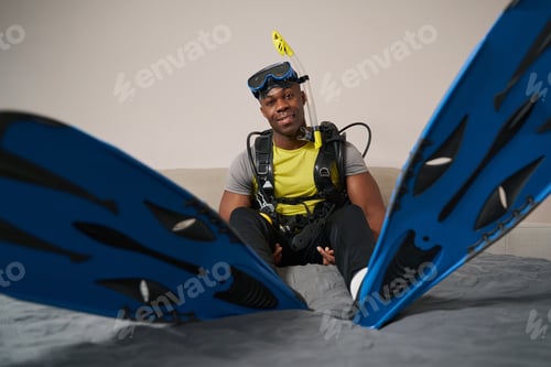Preview: Male showing swimfins of diving suit to camera
