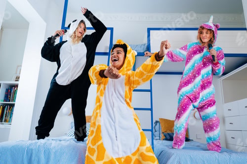 Preview: Multiethnic group of young female friends having pajamas party at home