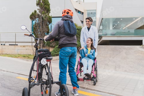 Preview: Doctor pushing woman in wheelchair next to adaptive bicycle